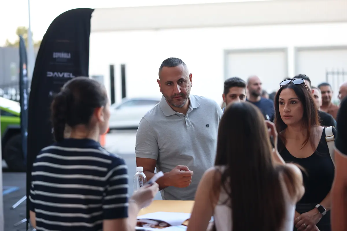 Guests checking in beside the sponsor flags