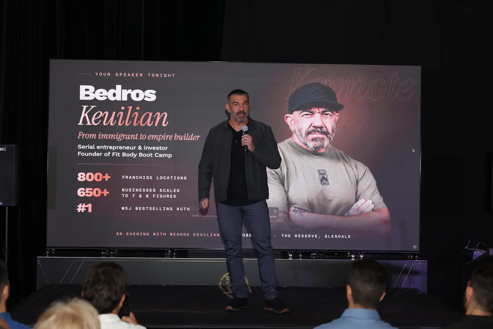 Bedros Keuilian on stage in front of his walk-on screen